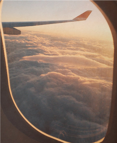 Airplane Window Over Looking Bright Clouds