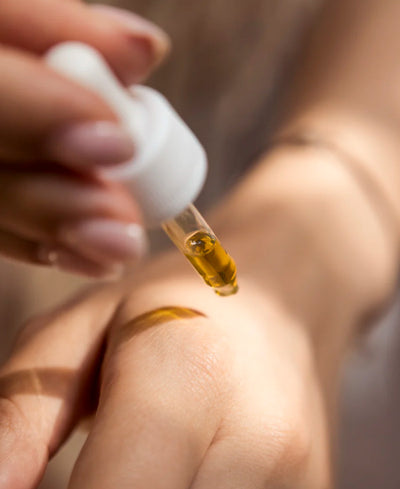 Woman Applying Face Oil To Skin