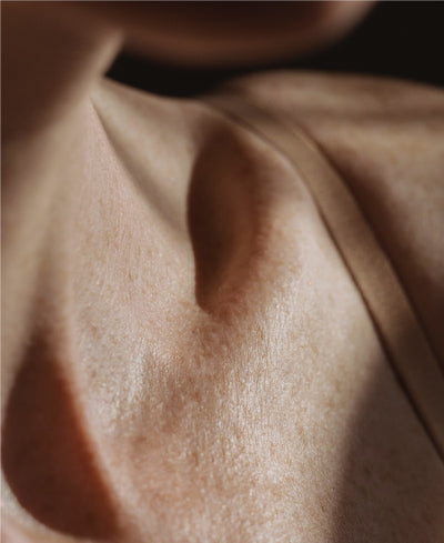 Light and Shadow Cascading Over Woman's Décolletage
