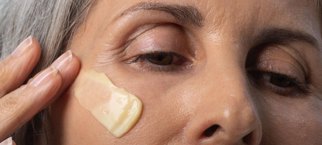 Woman Applying Face Cream To Cheek